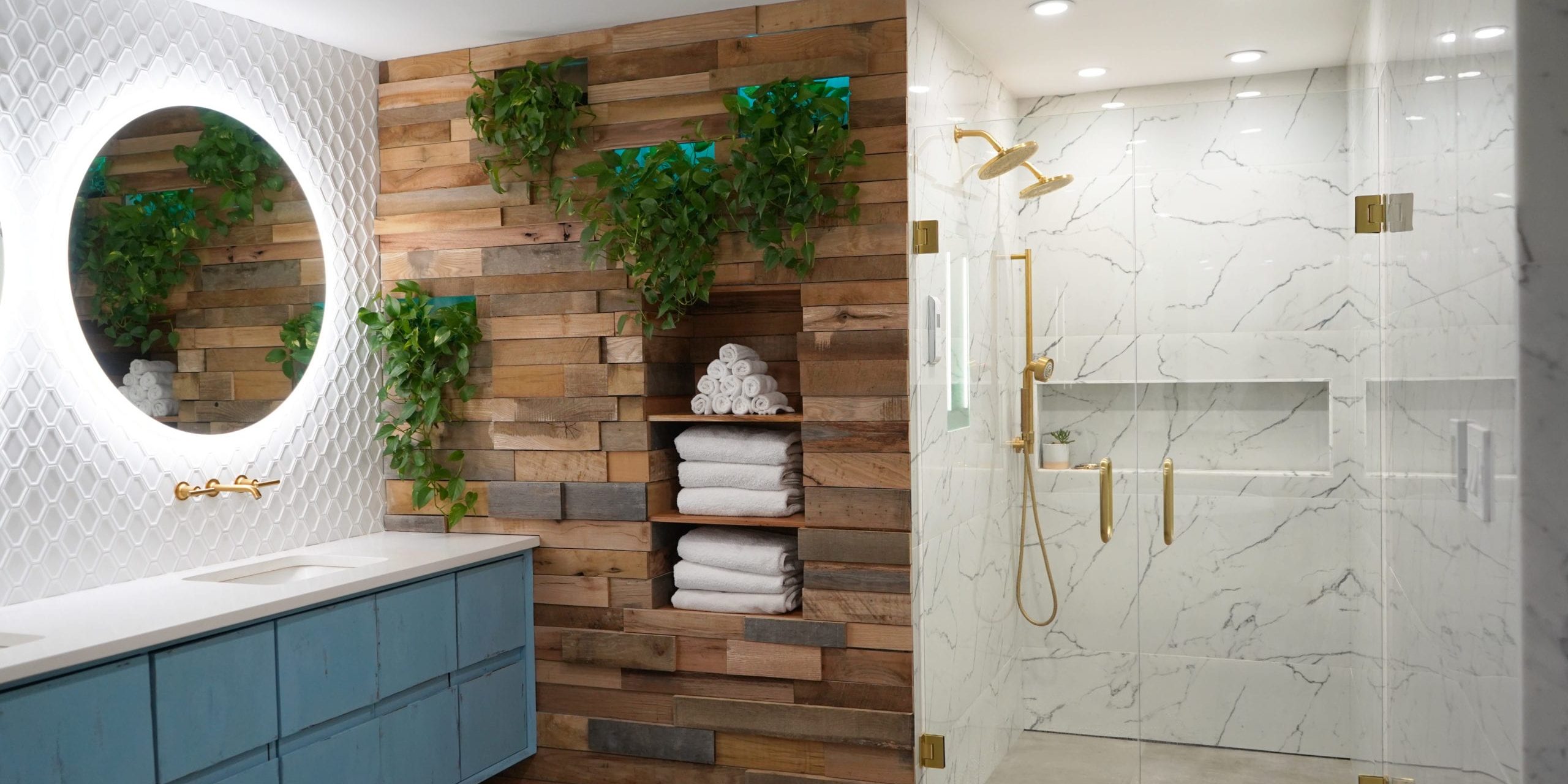 Bathroom Remodel Company in Atlanta with contemporary vanity, marble tile, walk in shower, gold shower, gold faucets, wood wall, white tile, round mirrors.